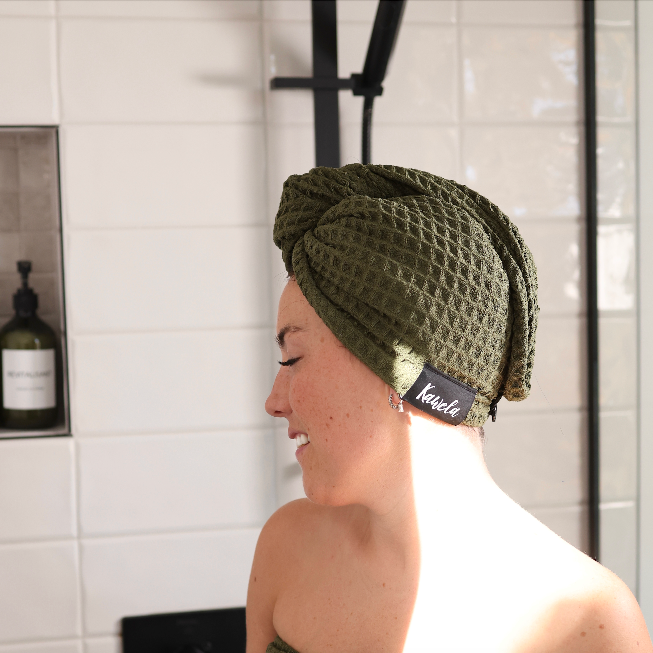 Serviette de bain KAWELÄ SINGAPOUR en coton doux avec motif coloré, pliée sur une surface en bois, vue de face.