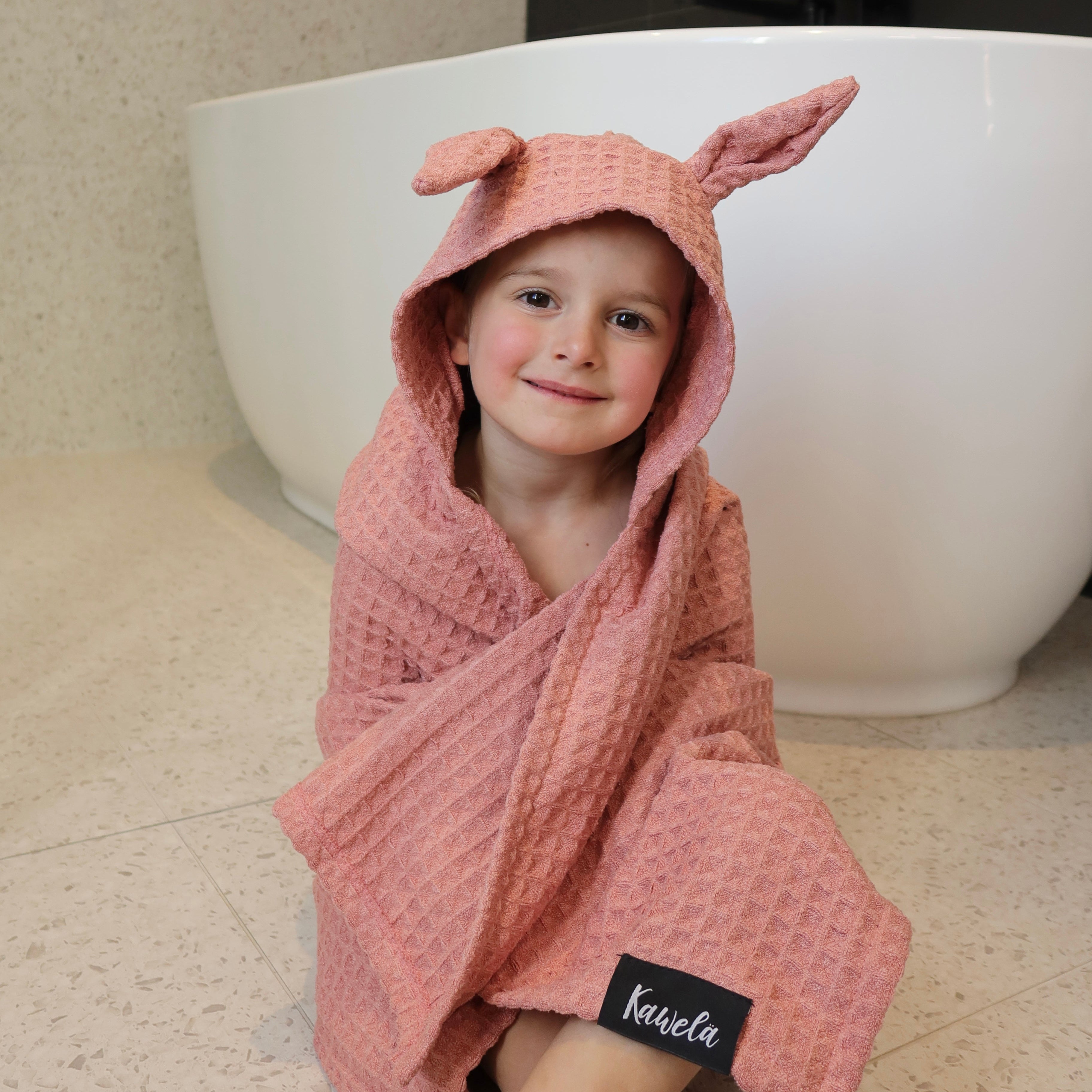 Serviette de bain pour enfant PINK LAKE de la marque KAWELÄ, en tissu doux rose avec motif enfantin.
