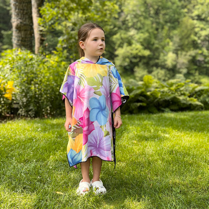 Poncho pour enfants KAWELÄ Clarence Town avec motifs colorés, porté par un enfant dans un environnement extérieur.