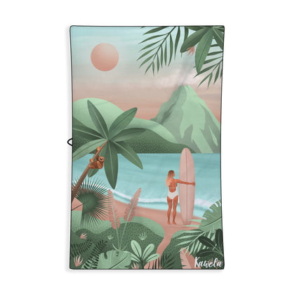 Serviette de plage Alajuela de la marque Kawelä avec motif coloré, étendue sur le sable pour une journée ensoleillée.