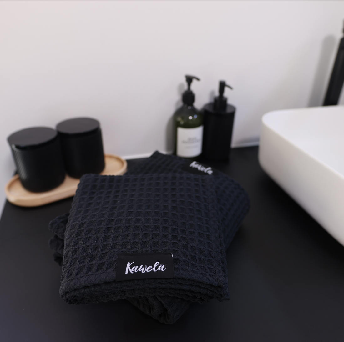 Serviette de bain noire KAWELÄ BLACKPOOL avec texture douce et absorption élevée, idéale pour la salle de bain.