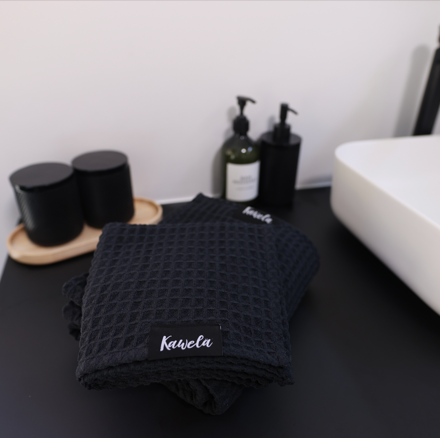 Serviette de bain noire KAWELÄ BLACKPOOL avec texture douce et absorption élevée, idéale pour la salle de bain.