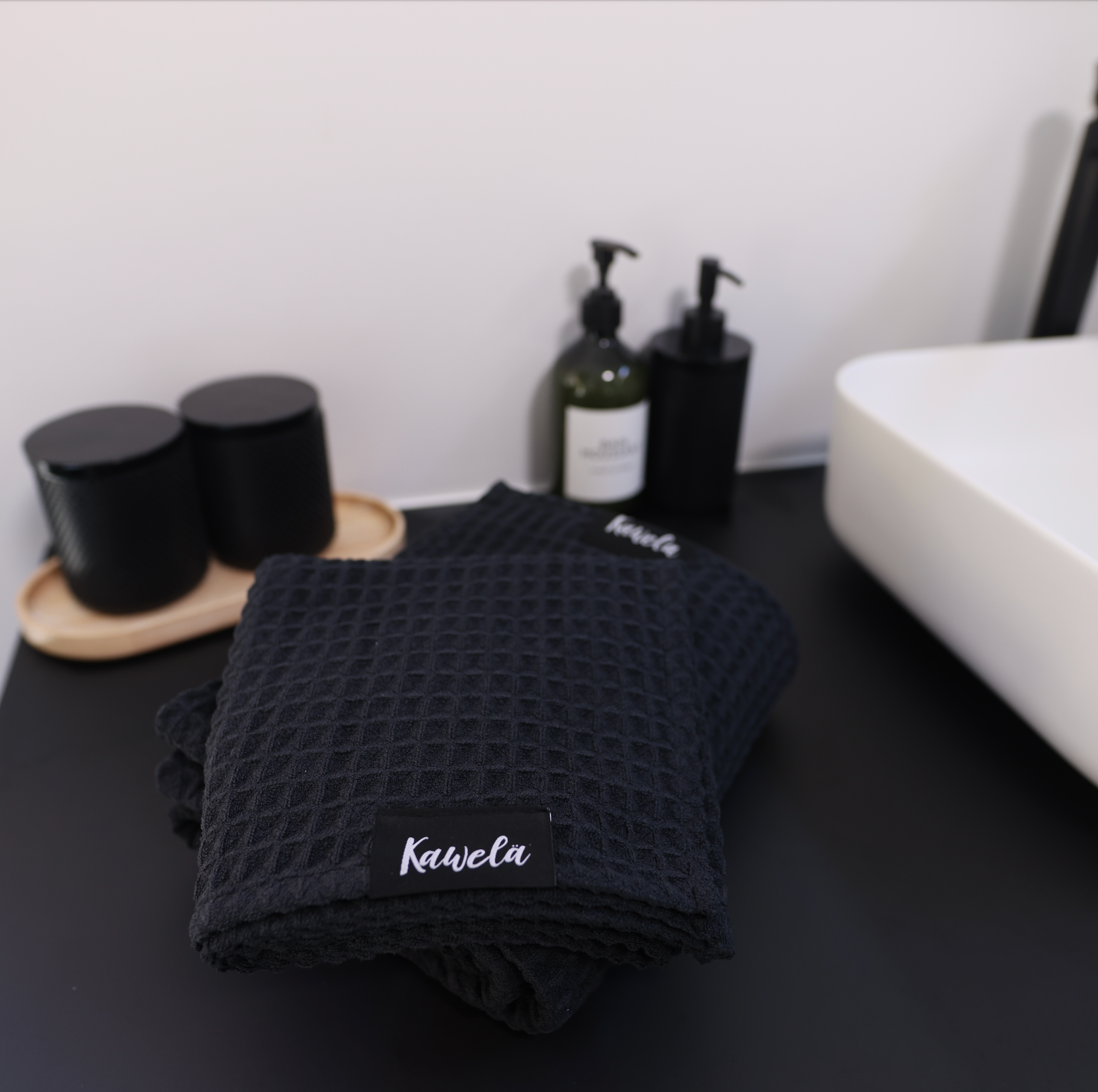 Serviette de bain noire KAWELÄ BLACKPOOL avec texture douce et absorption élevée, idéale pour la salle de bain.