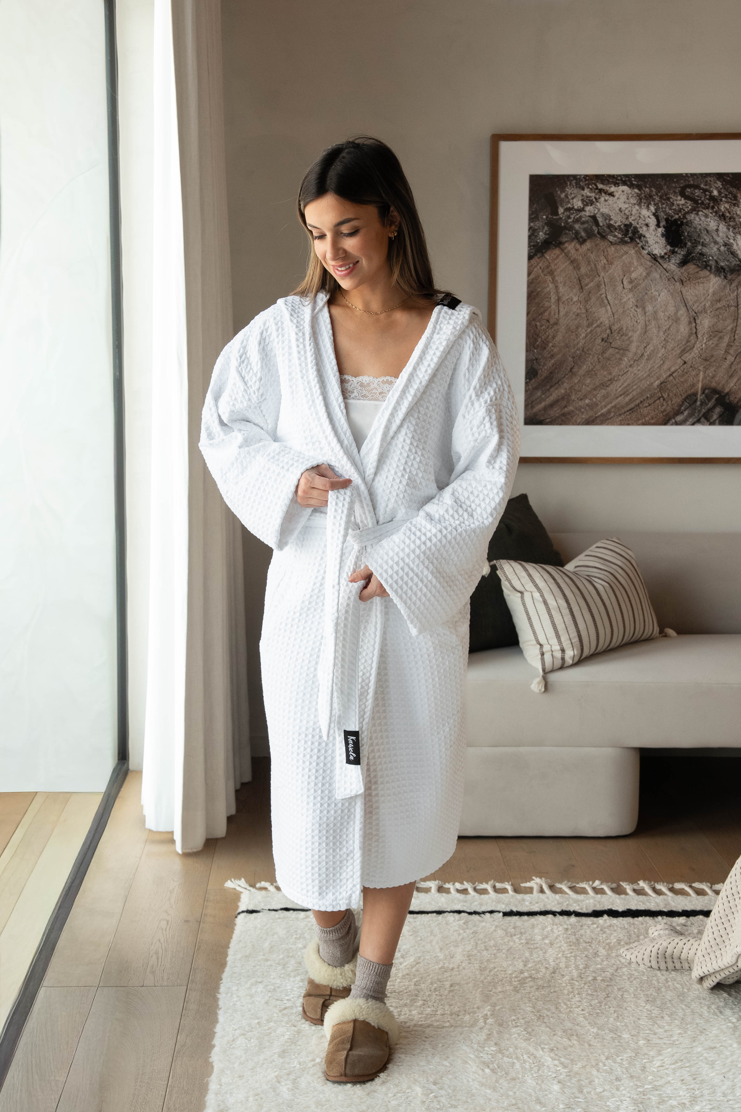 Serviette de bain blanche WHITEHORSE de la marque KAWELÄ, douce et absorbante, affichée sur un support avec texture en coton.