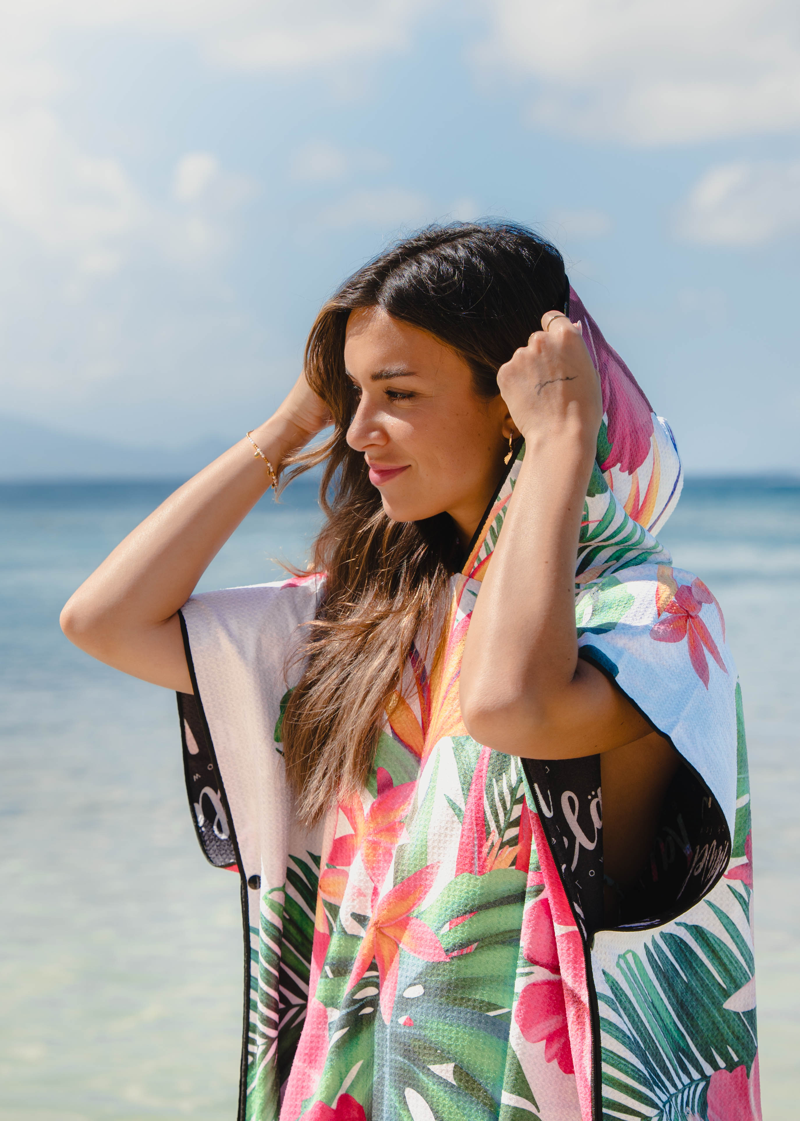 Poncho CRYSTAL RIVER de KAWELÄ en tissu léger avec motif coloré, porté en extérieur, vue de face.