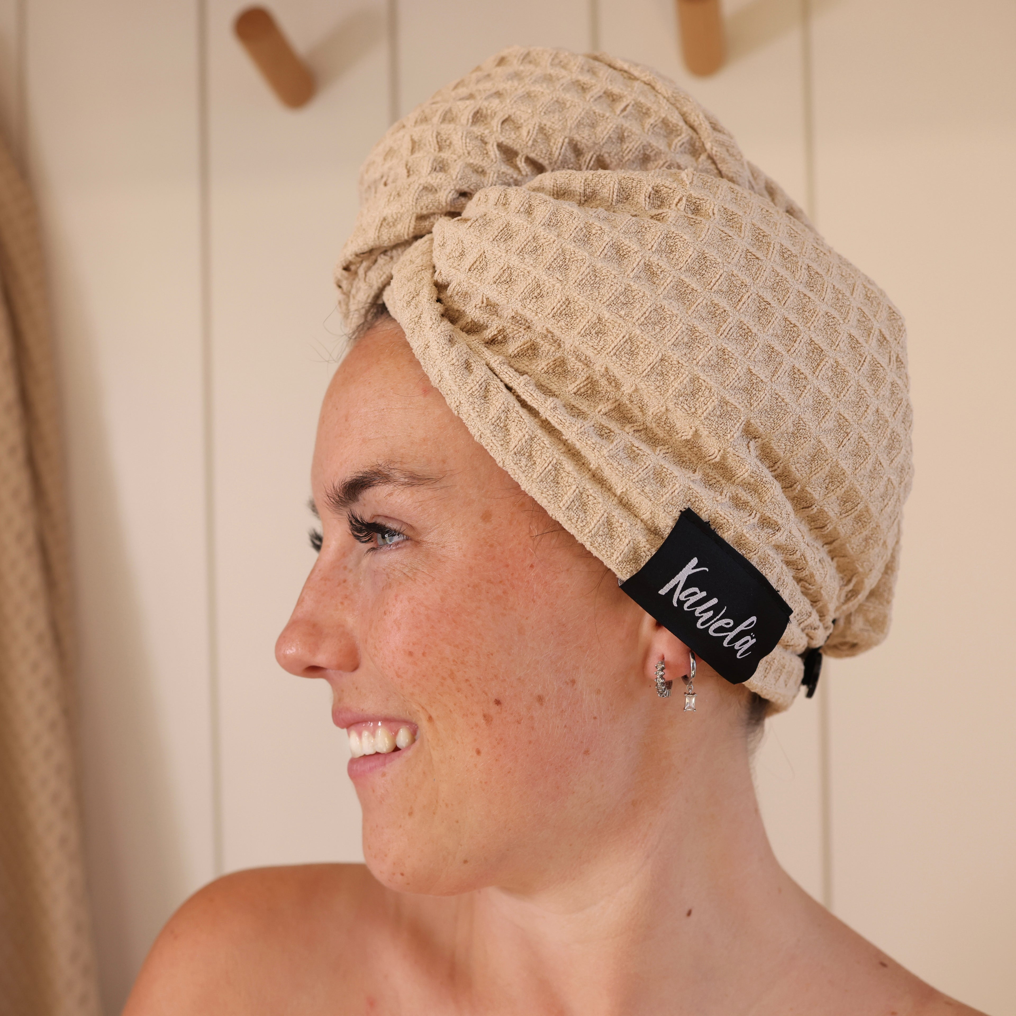 Serviette de bain NUDA de la marque KAWELÄ, tissu doux et absorbant, pliée sur un fond blanc.