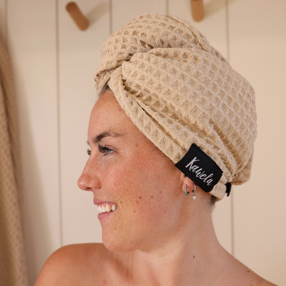 Serviette de bain NUDA de la marque KAWELÄ, tissu doux et absorbant, pliée sur un fond blanc.