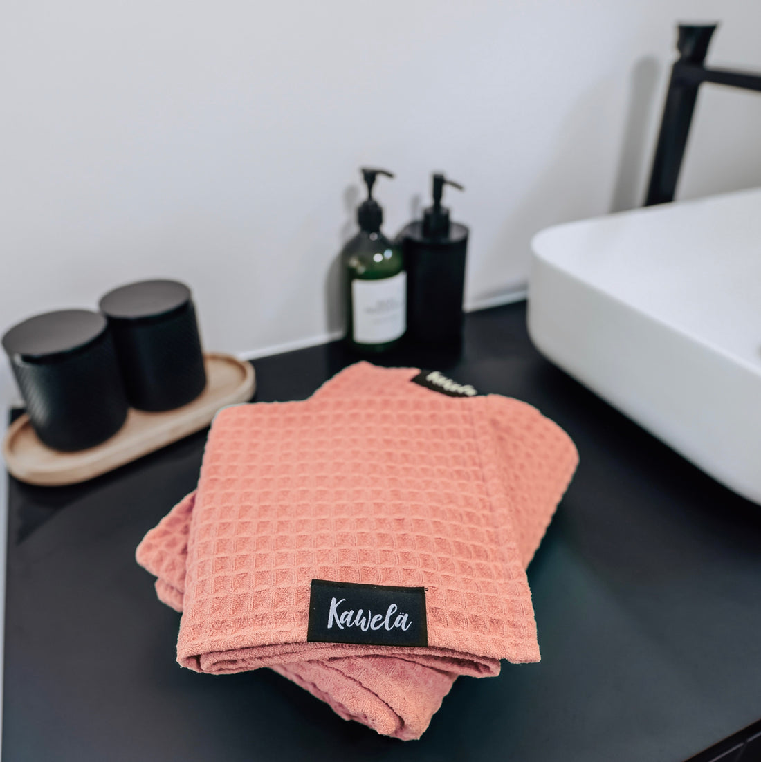 Serviette de bain rose PINK LAKE de KAWELÄ, texture douce et absorbante, pliée sur fond blanc, vue en gros plan.