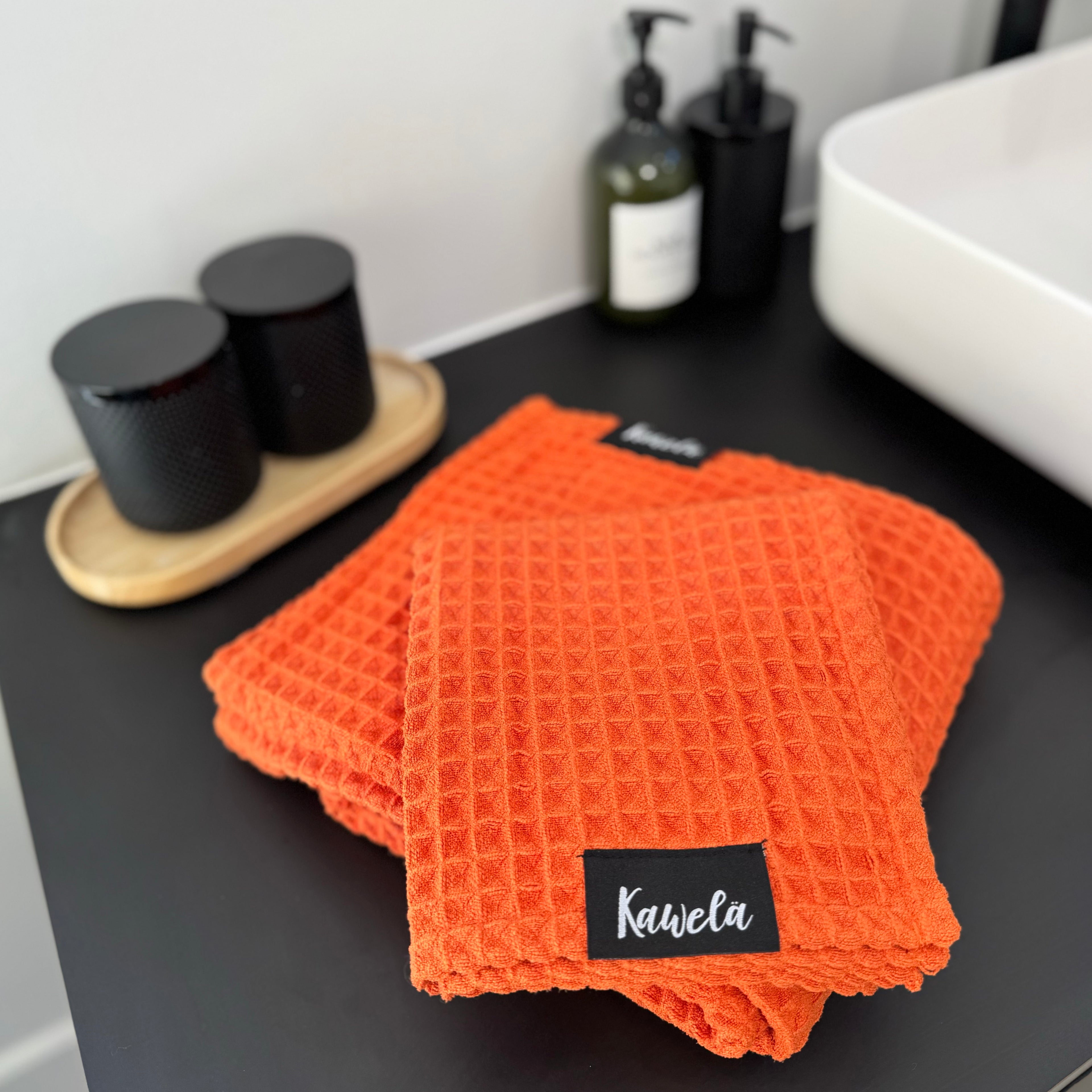 Serviettes de bain KAWELÄ NARANJA, tissu doux et absorbant, avec un design coloré en orange, visibles dans l&