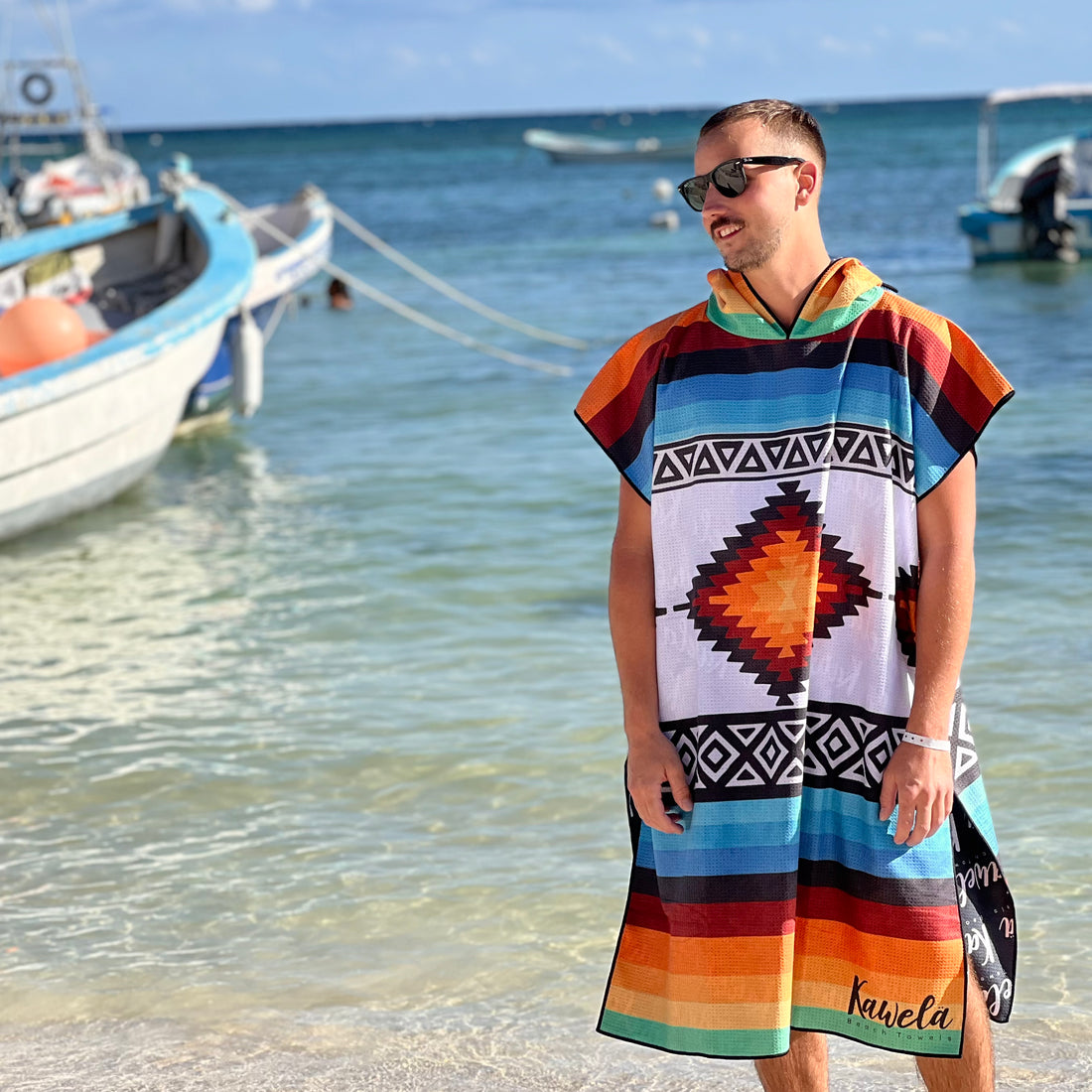 Poncho TAXCO de la marque KAWELÄ, en tissu coloré avec motifs traditionnels, porté par une personne.