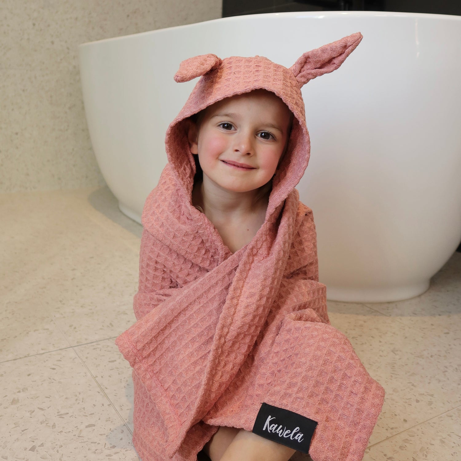 Serviette de bain pour enfant PINK LAKE de la marque KAWELÄ, en tissu doux rose avec motif enfantin.