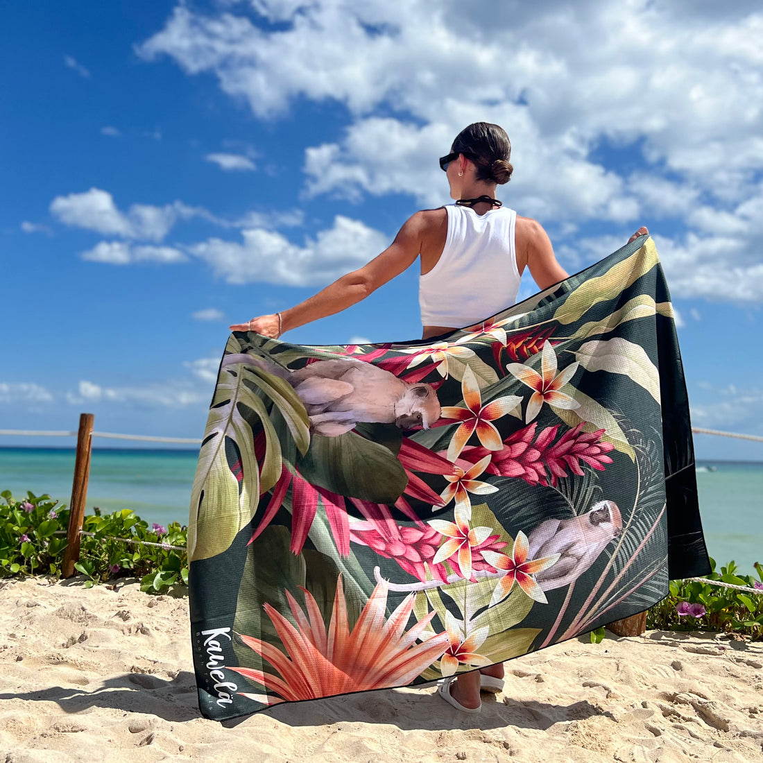 Serviettes de plage KAWELÄ TURRIALBA avec motifs colorés, étendues sur le sable lors d&