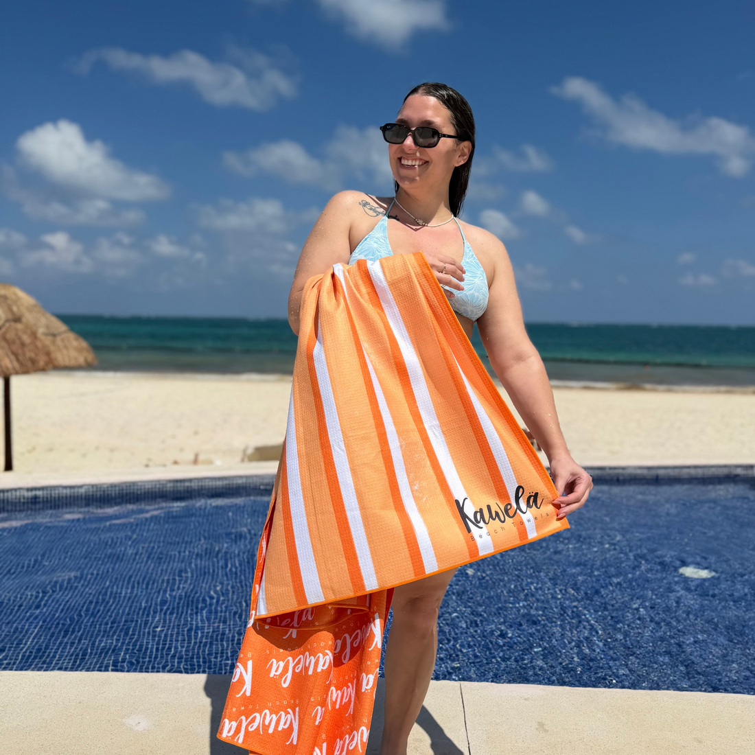 Serviette de plage KAWELÄ Marbella avec motif coloré, étendue sur le sable, idéale pour l&
