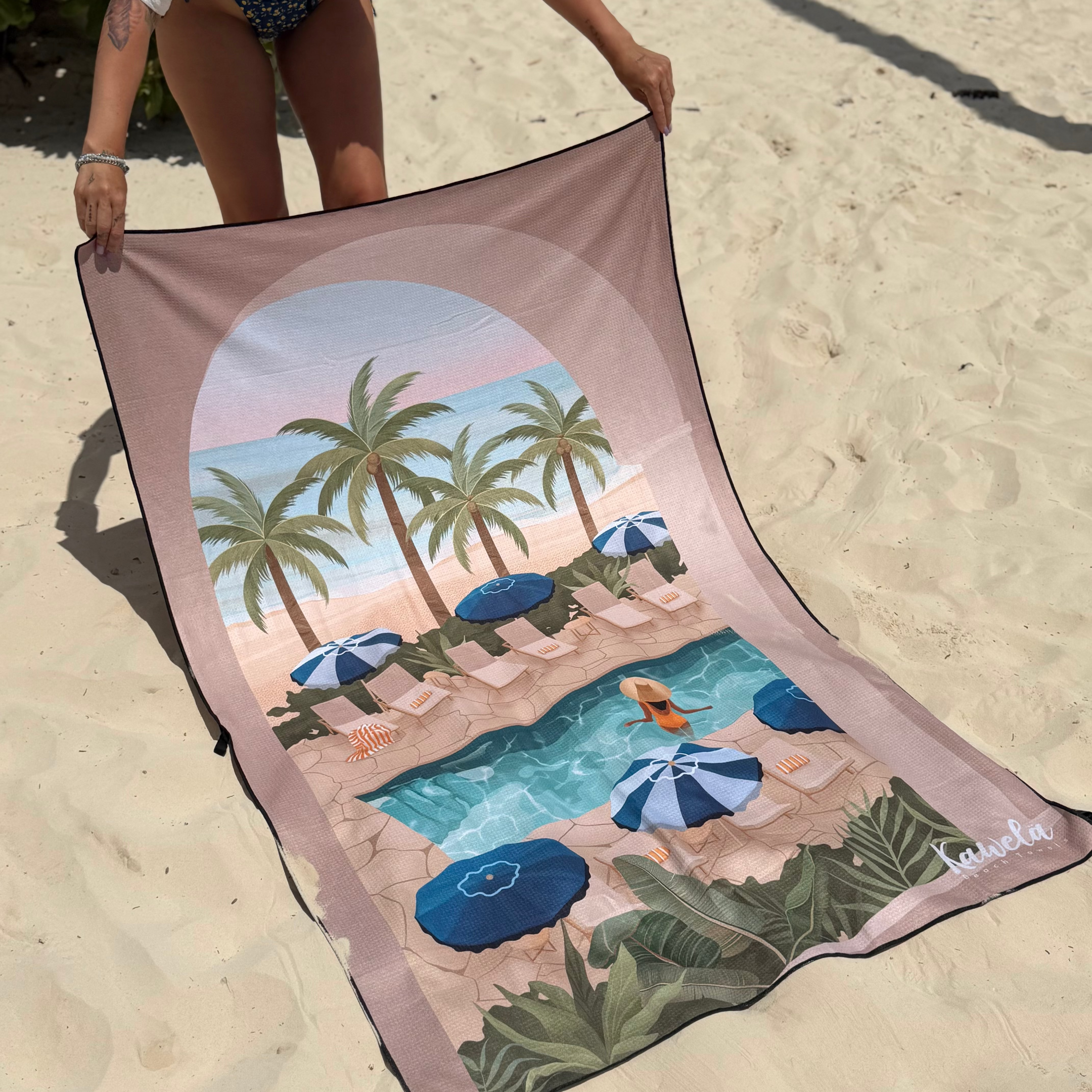 Serviette de plage KO SAMOUI de la marque KAWELÄ avec motifs colorés, étendue sur le sable, idéale pour l'été.