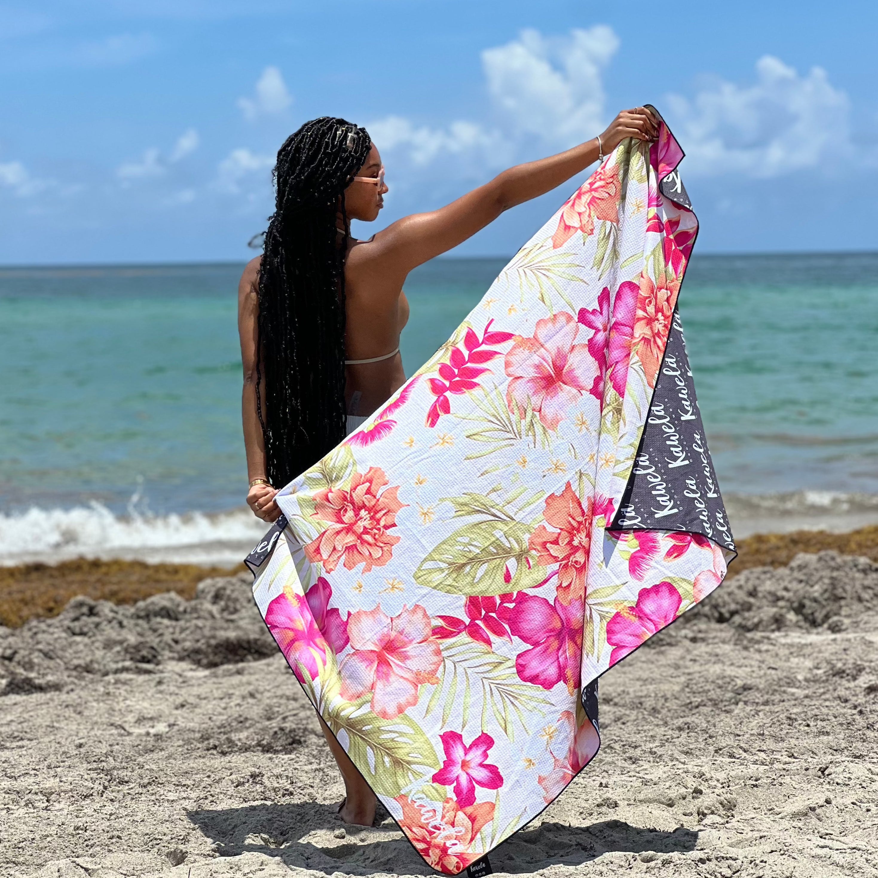 Serviettes de plage GEORGE TOWN de la marque KAWELÄ, avec motifs colorés et tissu doux, étendues sur le sable.