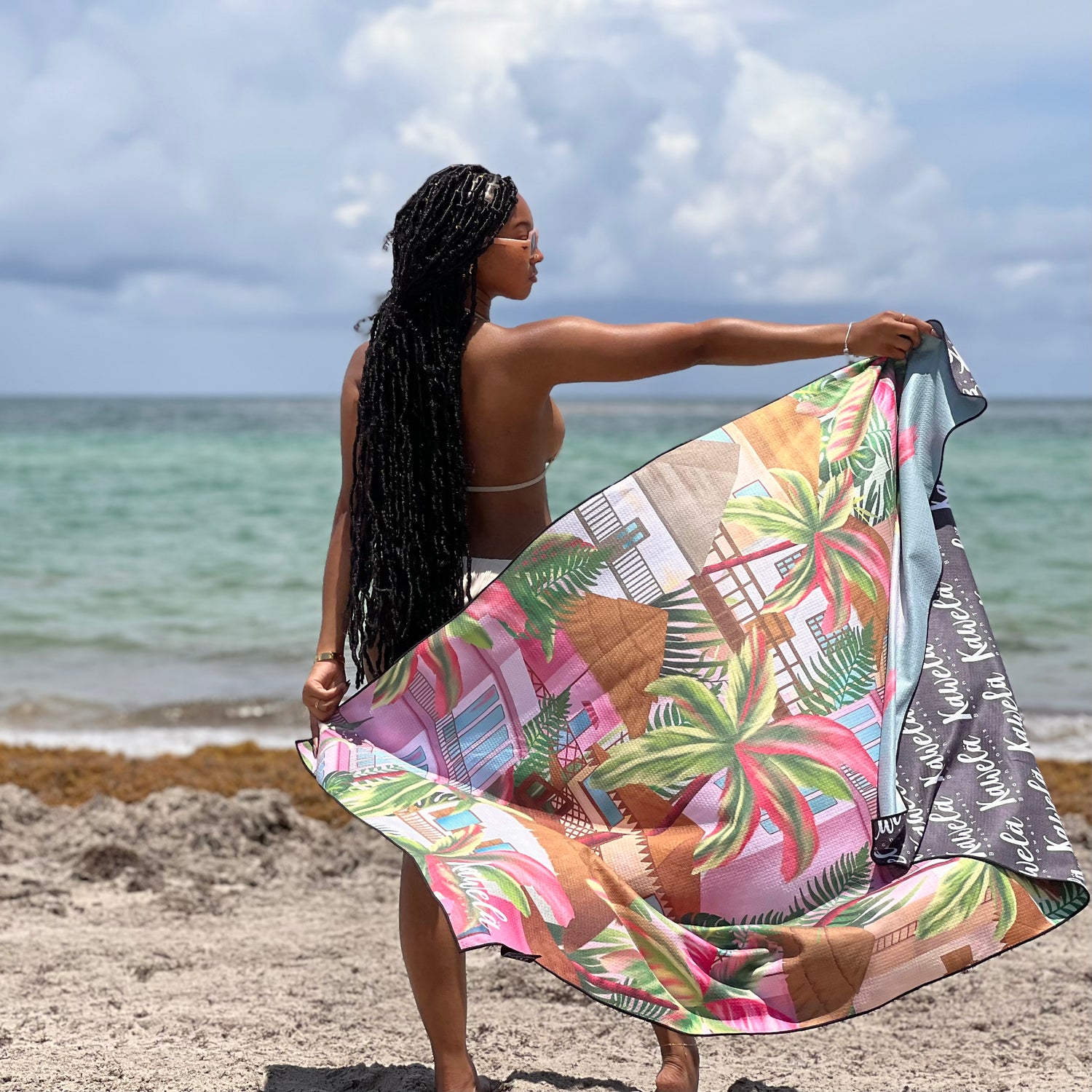 Serviettes de plage KAWELÄ FREEPORT avec motifs colorés, étendues sur une plage ensoleillée, tissu doux et absorbant.