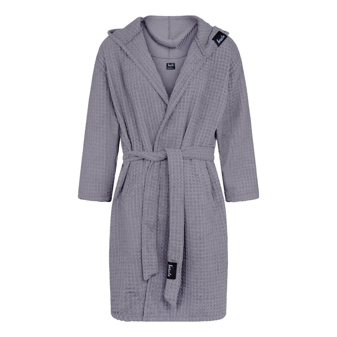 Peignoir BERLIN de KAWELÄ en tissu doux, posé sur une surface, avec un design élégant et une texture moelleuse visible.