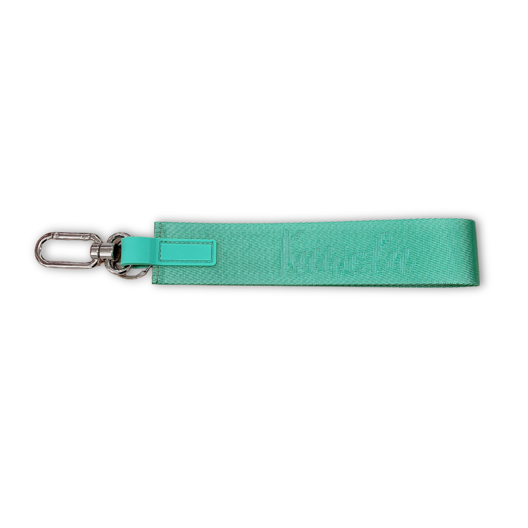 Porte-clés méga de couleur turquoise, assorti à un chapeau bucket KAWELÄ, avec détails en métal et design original.