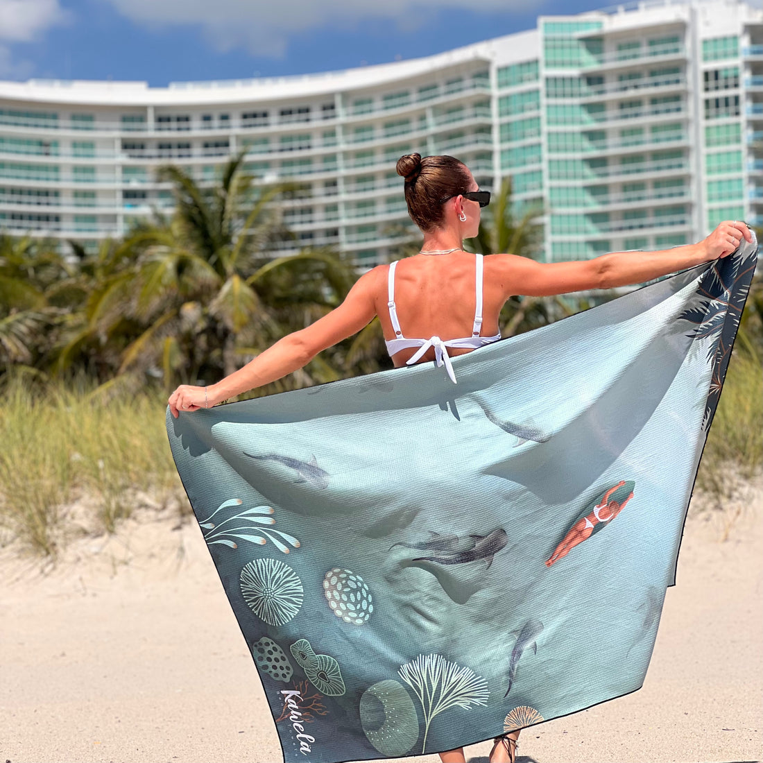 Serviette de plage KAWELÄ Nassau en coton coloré avec motif tropical, idéale pour la plage ou la piscine.