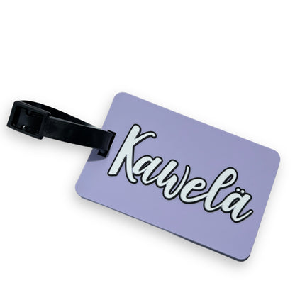 Identificateur de valise KAWELÄ avec étiquette colorée et poignée, conçu pour identifier facilement les bagages lors des voyages.
