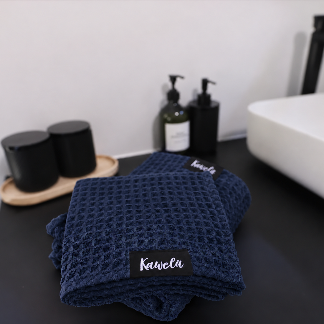 Serviettes de bain COPENHAGUE de KAWELÄ en tissu gaufré bleu marine, douce et absorbante pour la salle de bain.