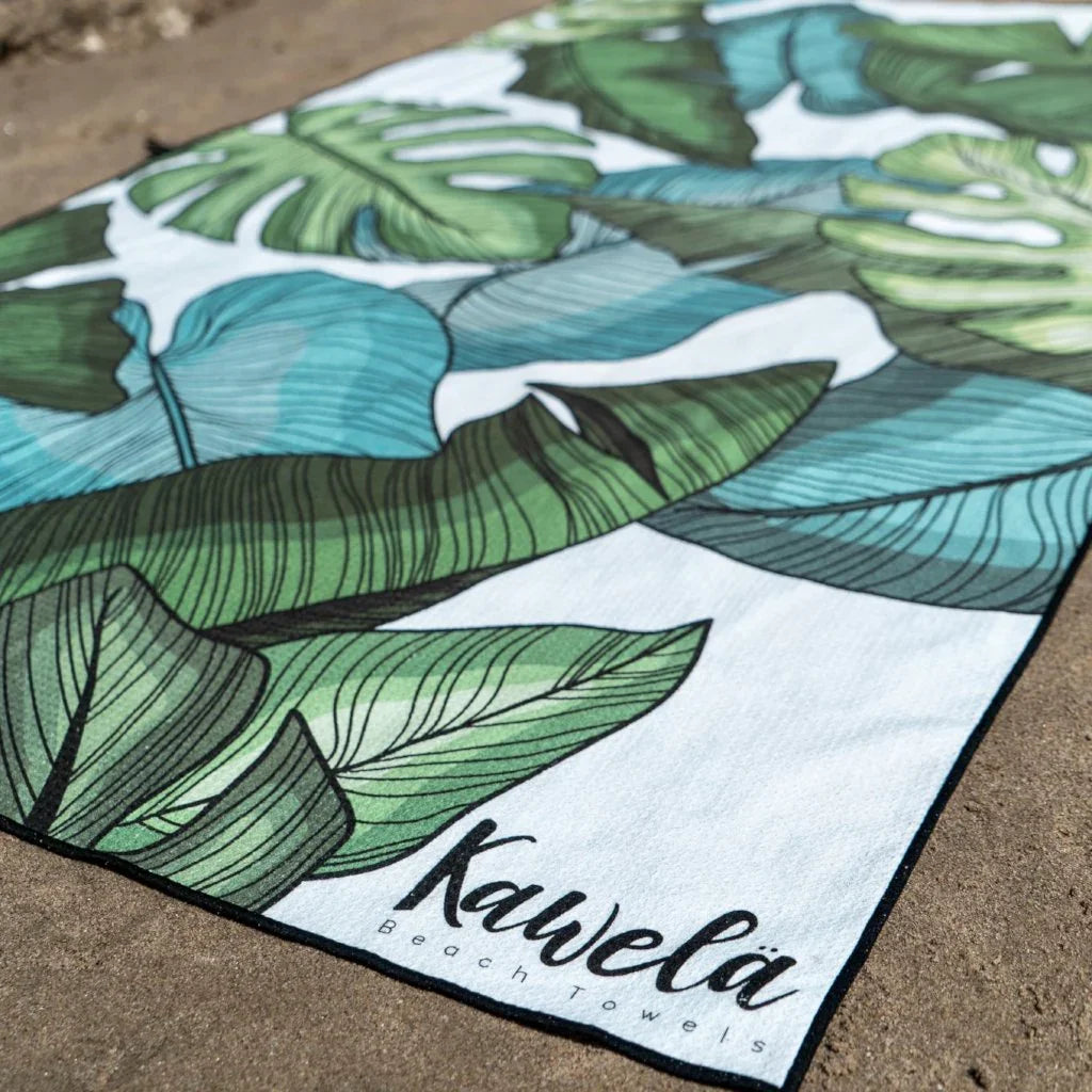 Serviette de plage Long Beach de la marque KAWELÄ avec motif coloré, étendue sur le sable.