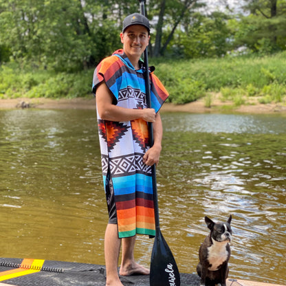 Poncho TAXCO de la marque KAWELÄ, en tissu coloré avec motifs traditionnels, porté en extérieur.