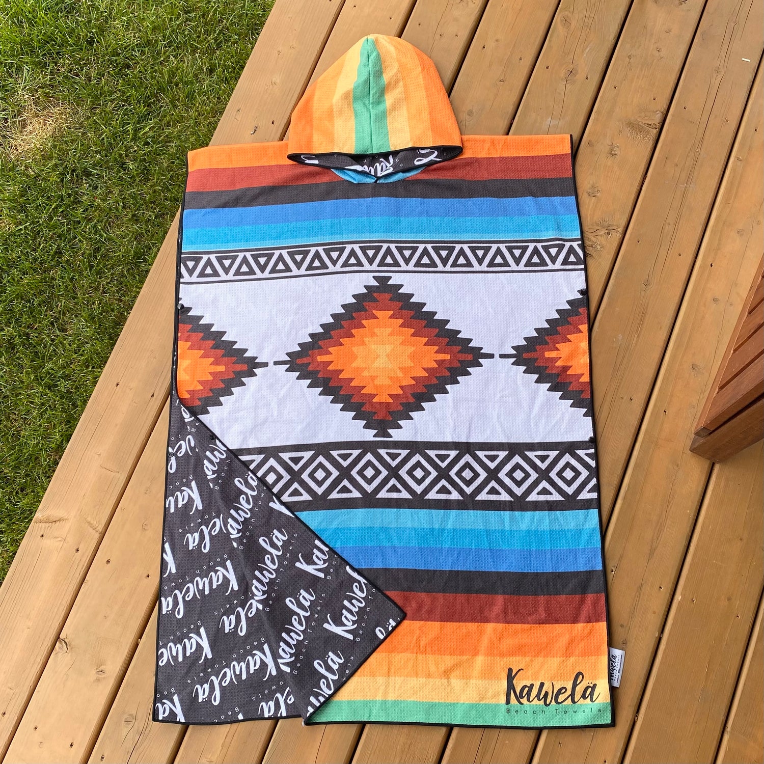 Poncho TAXCO de la marque KAWELÄ, en tissu coloré avec motifs traditionnels, porté en extérieur.