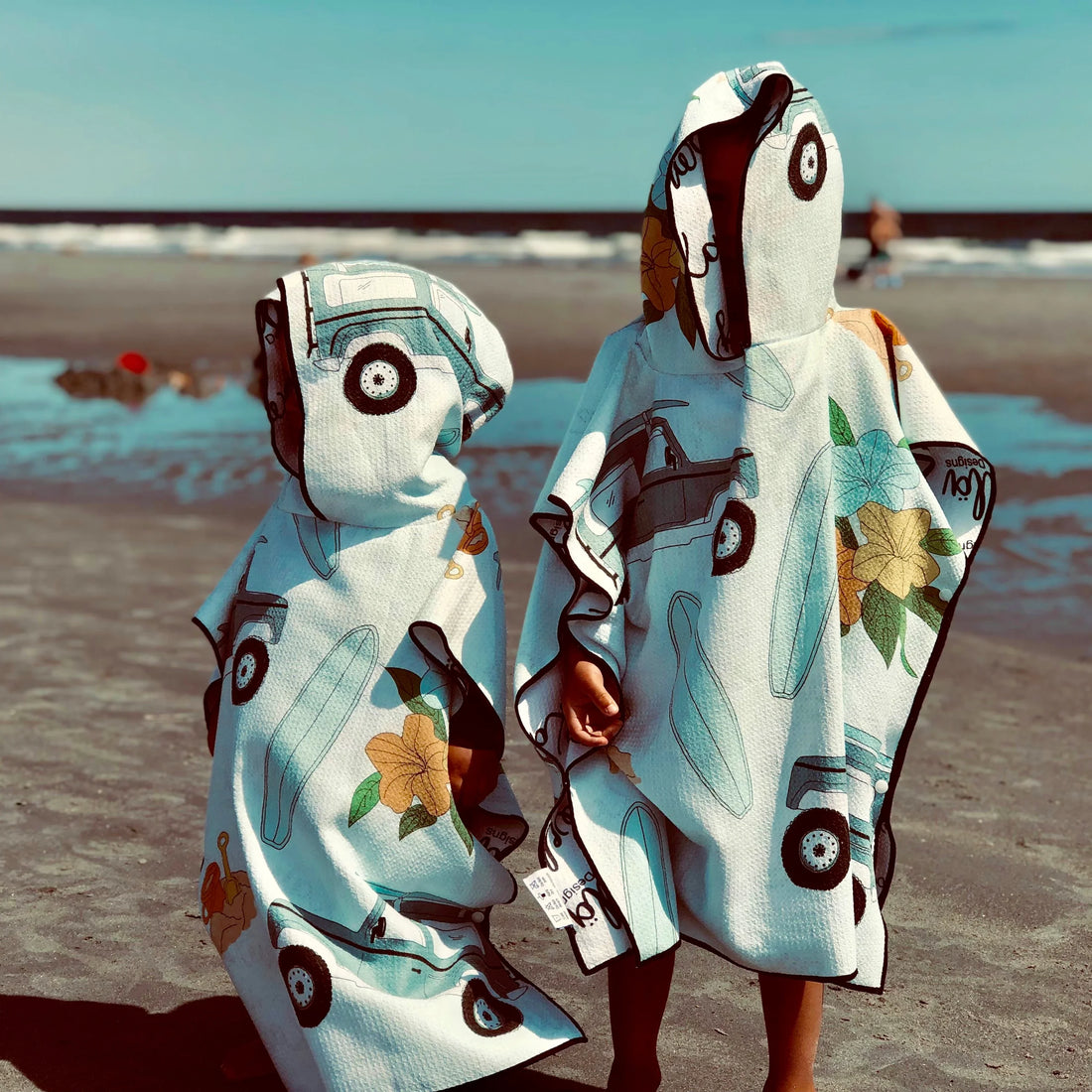 Poncho pour enfants Makaha de Kawelä, tissu coloré avec motif à rayures, adapté pour les activités extérieures.