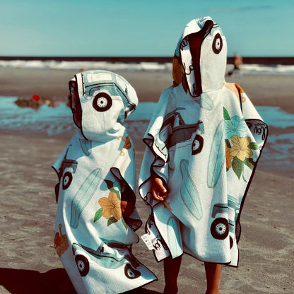 Poncho pour enfants Makaha de Kawelä, tissu coloré avec motif à rayures, adapté pour les activités extérieures.