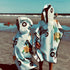 Poncho pour enfants Makaha de Kawelä, tissu coloré avec motif à rayures, adapté pour les activités extérieures.