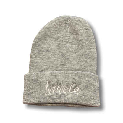 Tuque KAWELÄ en laine douce, portée sur une tête, avec un style chaud et confortable, couleur neutre, mode hivernale.
